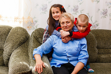 成年微笑的孙子们拥抱年迈的祖母 很高兴看到她想念她 亲戚的来访享受交流 拥抱作为联系 爱和支持理念的象征退休家庭成人关系老年朋友图片