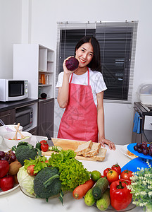 幸福的女子在厨房房间拿着紫色卷心菜食物胡椒蔬菜饮食营养房子女性沙拉围裙微笑图片