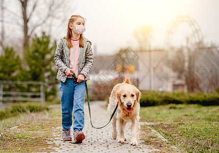 带着金色猎犬戴面罩的小女孩童年快乐娱乐乐趣头发友谊动物孩子面具宠物图片