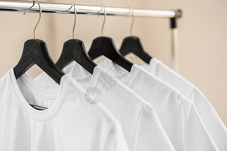 架上挂衣架上的白色T恤衫广告空白织物壁橱纺织品棉布衬衫服装衣柜服饰图片