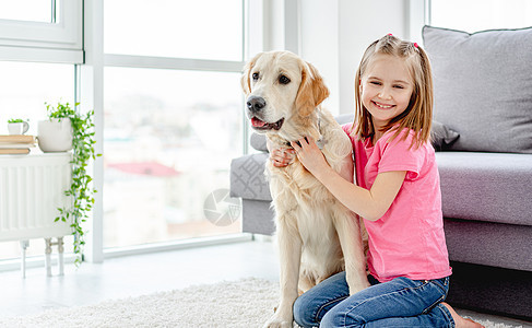 微笑的小女孩抱着可爱的小狗孩子闲暇沙发幸福友谊女孩喜悦动物女学生房间图片