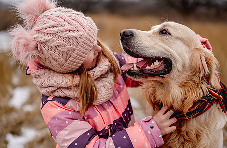 抱着金色猎犬狗的小女孩忠诚动物成人宠物友谊拥抱场地毛皮犬类朋友图片