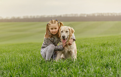小女孩在田里抱小狗忠诚喜悦快乐微笑享受女孩友谊猎犬朋友哺乳动物图片