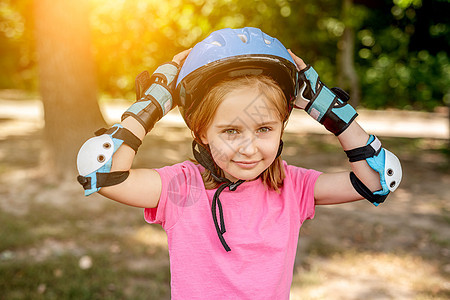 参加体育保护设备运动的小女孩安全轮滑溜冰者滑冰街道滚筒冰鞋孩子公园旱冰图片