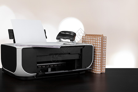 架在桌上的压缩家庭打印机 书面模糊背景的书籍激光技术打印文书桌子扫描器文档扫描电子产品复印件图片