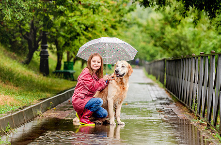 小女孩与狗同雨伞宠物乐趣下雨女学生天气朋友靴子街道胡同微笑图片