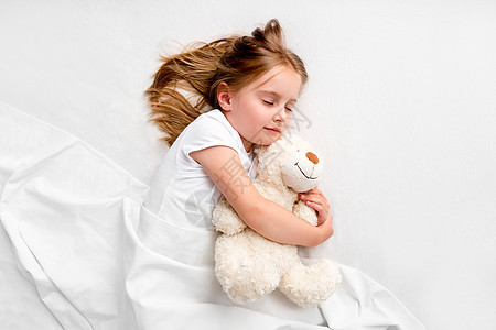 女孩抱着泰迪熊躺在床上就寝枕头童年时间说谎孩子幼儿园拥抱用品头发图片