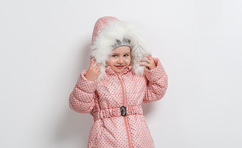 穿着兜帽外套的可爱小女孩夹克帽子婴儿衣服白色喜悦季节粉色童年快乐图片