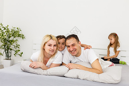 年轻家庭一起在父母的床上休息姐姐男生爸爸乐趣女儿孩子儿子感情父亲生活图片