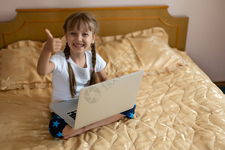 免费教育 业余时间 技术和互联网概念     家里有笔记本电脑的小女孩青少年孩子小学生女孩学习童年微笑学者学生青春期图片