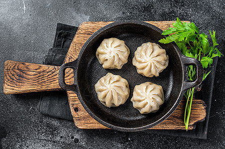 含有药草的锅盘中填充的肉片子 黑色背景 顶视图盘子点心小吃汽船面团白色猪肉煮沸竹子蔬菜图片