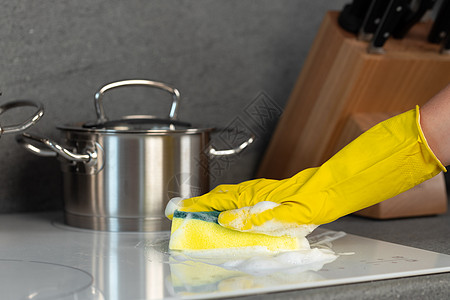 女性手握黄色手套 用海绵清洗电炉灶抹布灰尘家务家庭工作清洁工卫生服务溅射乳胶图片