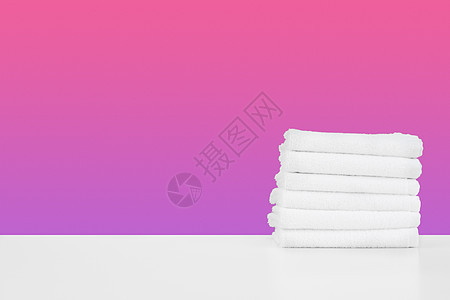 白桌上用彩色背景堆放干净的毛巾沙滩抹布家务工具家政卫生折叠织物棉布产品背景图片