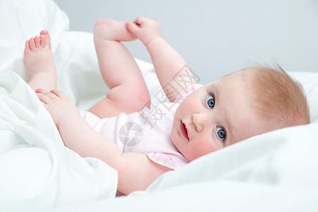 婴儿用脚玩耍金发孩子们幸福眼睛女孩卧室孩子毯子童年快乐图片