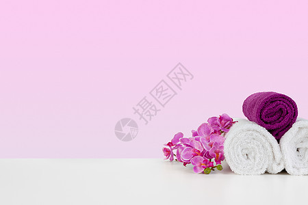 粉红背景的美丽的粉红色花朵和白毛巾花园卫生温泉洗澡花束折叠浴室纺织品白色棉布图片