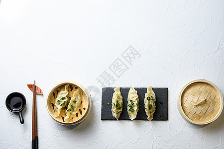 概念中国小吃 中国蒸饺日本饺子或木制蒸锅中的饺子小吃 并在黑石板上加酱油作为晚餐午餐 传统的亚洲日本中国菜文本的顶视图空间图片