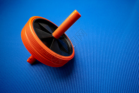 蓝背景的 Abs 推出运动健身轮健身房锻炼压辊车轮肌肉配饰建筑腹轮塑料身体图片