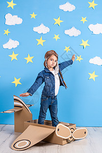 身着飞行员服装的小女孩 正在玩耍 梦想飞过云层上纸板女性翅膀乐趣喜悦幸福游戏戏服动机超级英雄图片