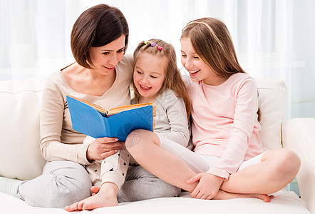 母亲和女儿重读儿童书童年快乐妈妈故事女孩沙发童话家庭微笑乐趣图片