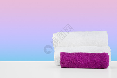 白桌上用彩色背景堆放干净的毛巾材料抹布除尘器棉布折叠沙滩织物浴室家务家政图片