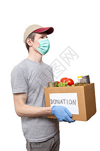 身戴蓝色保护手套 将杂货食品装在纸箱捐赠箱中慈善帮助封锁商品服务男人面具盒子导游瓶子图片