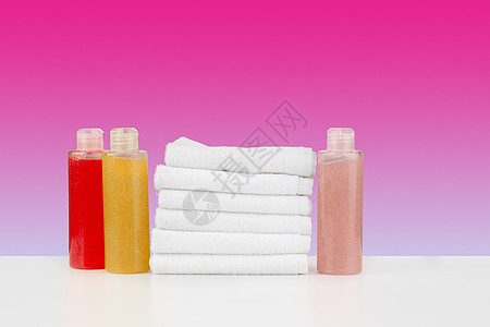 毛巾 白桌上有洗发水的瓶子浴室桌子淋浴推广身体肥皂奶油化妆品配件温泉图片
