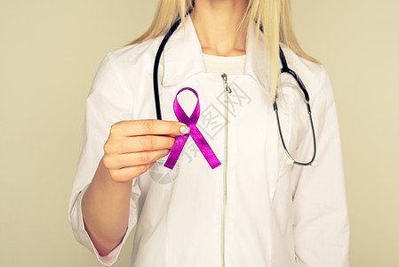 身穿白色制服的女医生手持紫色丝带 用于治疗 ADD ADHD 阿尔茨海默病 畸形 儿童偏瘫中风 癫痫 慢性急性疼痛 克罗恩病斗争图片