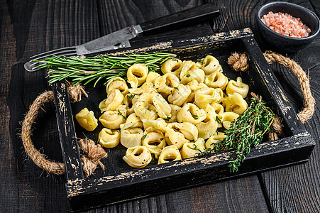 木盘中含有菠菜 黑木背景 顶部视图的意大利传统面粉和菠菜烹饪黄色黑色食物盘子午餐饺子黄油草本植物美食图片
