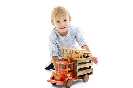 小男孩在玩木制汽车教育男生学习运输车轮男性车辆幼儿园家庭活动图片