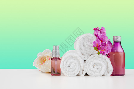 白桌上堆满白毛巾和一瓶皮肤护理奶油身体擦洗肥皂治疗产品温泉洗发水桌子浴室图片