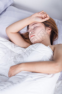 睡在卧室床上的妇女女性女孩女士闲暇枕头白色微笑说谎成人寝具图片