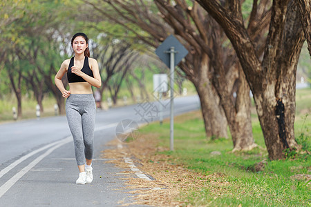 在公园中奔跑的健身妇女运动装女孩女性成人街道训练活动树木娱乐慢跑者图片