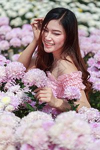 在菊花发光园中的美丽女子微笑花园花店阳光头发女性女孩公园成人幸福图片