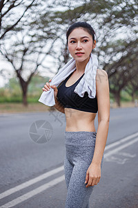 在公园户外露天锻炼运动后 穿着白毛巾的年轻运动女青年运动者休息训练慢跑者瓶子女孩活力成人跑步女性花园赛跑者图片