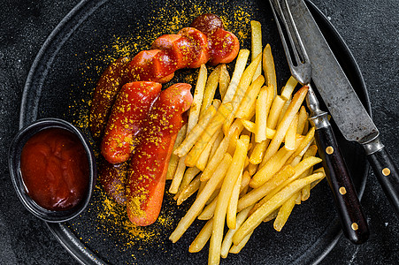 传统德国咖哩wurst 配有薯条 黑色背景油炸食物猪肉炙烤小吃盘子香料服务烧烤土豆图片