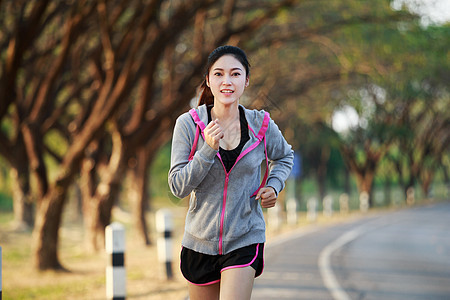 在公园中运行的健身妇女树木女士活动训练娱乐女孩运动街道赛跑者成人图片