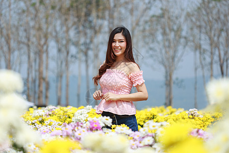 在菊花发光园中的美丽女子成人花园园丁公园女性花店女孩微笑头发幸福图片