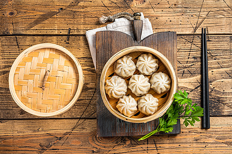 竹蒸汽机中的莫莫小龙卷子 木质背景 顶层视图白色食物蔬菜筷子小吃盘子竹子饺子烹饪黑色图片
