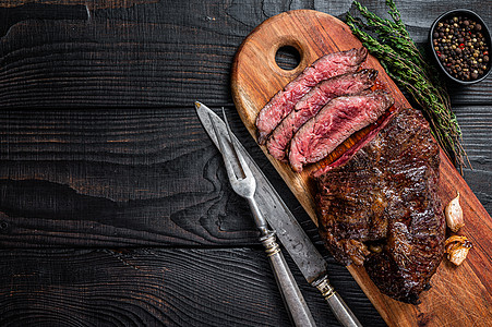 烤屠夫精选牛排 Onglet 将嫩牛肉挂在砧板上 黑色的木制背景 顶视图 复制空间烹饪食物裙子饭馆牛扒烧烤盘子酒吧香料木板图片