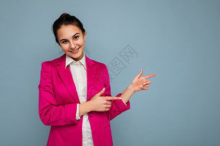 年轻迷人 美丽 积极 快乐 微笑的黑发女人的照片肖像 她带着真诚的情感 穿着休闲的白衬衫和时尚的粉色夹克 隔离在蓝色的墙上 有自图片