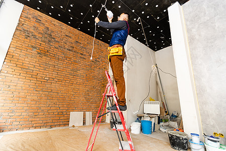 电动修理天花板灯 工作维修电气职业反抗建设者工人电压服务男性工具图片