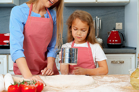 母亲和女儿在厨房里准备钱财 在厨房里做饭桌子烹饪馅饼孩子乐趣快乐父母妈妈母性面粉图片