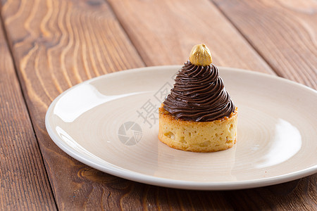 上面加巧克力奶油和金坚果食物蛋糕脆皮美食可可糖果圆形棕色甜点面包图片