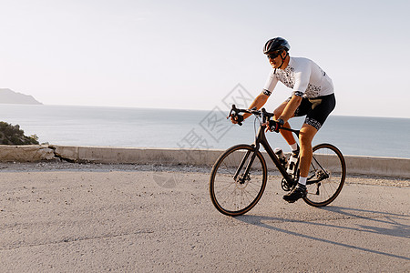 职业道路自行车赛手在山区公路上行驶自行车运动太阳镜行动速度男性运动员骑士头盔肌肉图片
