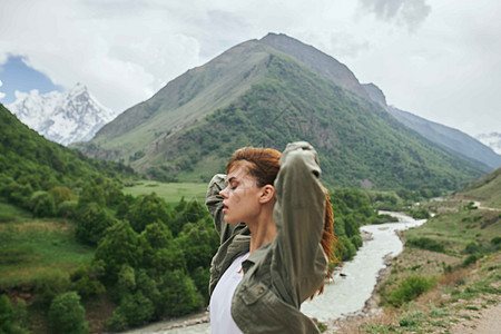 妇女登山者山地风景漂浮在新鲜空气中天空远足自由背包女性边缘岩石阳光日落太阳图片