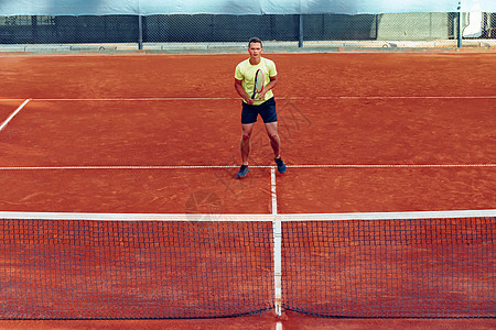 在网球场打网球的英俊男运动球拍玩家男性网球运动装游戏法庭训练图片