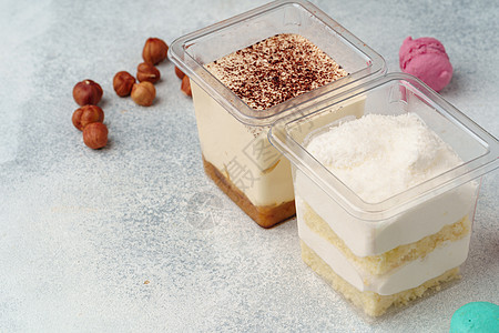 灰色桌上塑料盒中的奶油甜点美食塑料蛋糕糕点可可咖啡店罐子礼物方罐食物图片