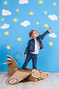 身着飞行员服装的小女孩 正在玩耍 梦想飞过云层上童年戏服自由超级英雄航班飞机探险家纸板英雄天空图片