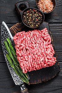Raw mince 羔羊 土肉和草药以及木制切割板上的香料猪肉迷迭香大理石纹肉馅黑色胡椒食物红色地面屠夫图片