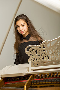 女孩在白色大钢琴上艺术乐器孩子键盘音乐家奢华成人音乐会音乐学习图片